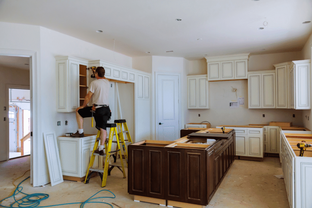 man installing kitchen cabinets
